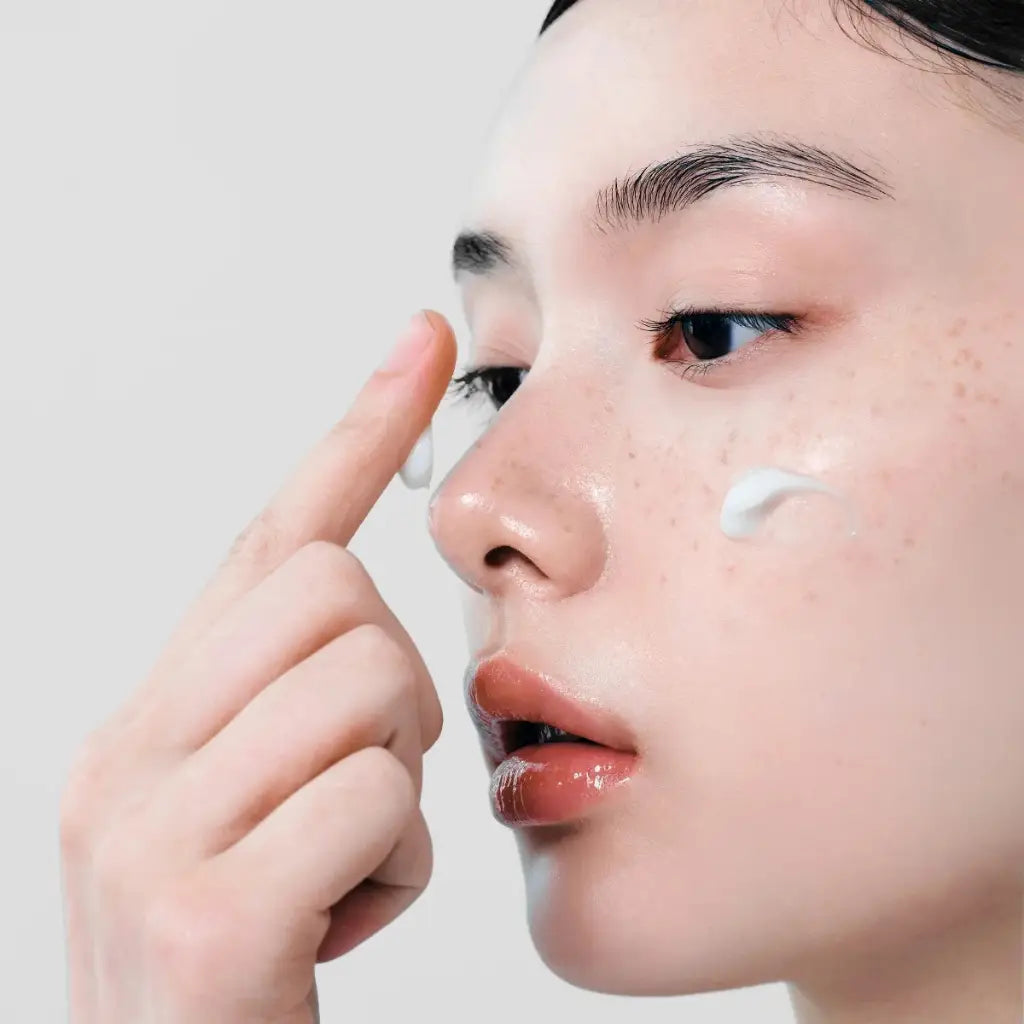 Close-up of a woman applying Dr.Althea 147 Barrier Cream 50ml, texture on her face